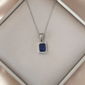 Close-up of a blue rectangular zircon pendant on a silver chain in a luxury jewelry box - Blue