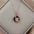 Detail of gold Leo zodiac necklace with lion head and star on black enamel pendant - Gold-Leo