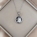 Detailed close-up of a silver zodiac pendant in a luxury jewelry box with silk lining - Silver-Gemini