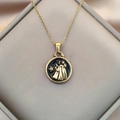 Close-up of golden Gemini zodiac pendant with black enamel on champagne satin - Gold-Gemini