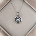 Detailed macro view of Taurus zodiac pendant necklace with black enamel and silver bull relief - Silver-Taurus