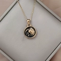 Close-up of golden zodiac necklace with lion pendant on black enamel in a jewelry box - Gold-Lion
