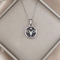 Detailed close-up of a silver Aries ram pendant with a black enamel finish and star detail - Silver-Aries