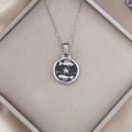 Detailed macro view of Pisces zodiac pendant on black enamel background with silver chain - Silver-Pisces