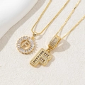 Detail of two gold-plated letter F pendants with sparkling cubic zirconia inlay - Letter F