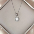 Close-up of square zircon pendant necklace on luxury silk in a jewelry box - White