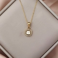 Detail of square halo zircon pendant on a gold necklace displayed in a luxury jewelry box - Ivory