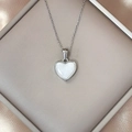 LUCKY heart pendant necklace with pearl-like finish in a beige jewelry box on silk fabric - White