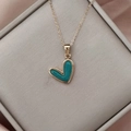 Detalle del colgante de corazón dorado con incrustación de turquesa en caja de lujo - Dorado Verde Oscuro