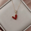 Vista macro detallada del collar con colgante de corazón y cadena de oro en caja regalo - Gold Deep Red