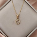 Detailed close-up of golden necklace with pink gemstone sunflower pendant on silk - Pink