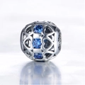 Detail van een S925 zilveren bedel met opengewerkte harten en drie blauwe edelstenen - Hart Hol Ingelegde Blauwe Strass Stijl (15 X447)