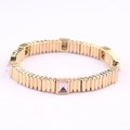Detailed shot of elastic gold metal bracelet featuring inlaid pink rectangular gemstones - Light Pink