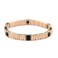 Detailed macro view of gold-tone elastic bracelet featuring black square gemstones - Black