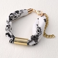 Nahaufnahme eines bedruckten Seidenarmbands mit goldener Metallhülse und Karabinerverschluss - Schwarz-Weiß Druck Stil (SB02-1)