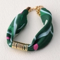 Detalle de una pulsera de tela con motivo floral verde oscuro y anillos de metal dorado - Estilo de Lunares Verde Oscuro (SB02-8)
