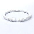 Detail shot of the white matte twisted cable open bangle with conical finial ends - White
