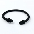 Detailed close-up of a matte black cable wire twisted cuff bracelet with sphere finials - Black