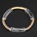 Nahaufnahme der goldenen Metallscheiben und transparenten Acrylperlen auf dem Perlenarmband - Klarweiß