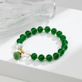 Dettaglio di perle verde scuro con ciondolo a fiore di loto intagliato e accenti dorati - Verde Effetto Giada (GBC02-11)
