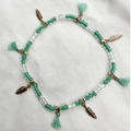 Detalle de tobillera bohemia de cuentas con colgante de pluma dorada y borlas verde menta - Estilo Pluma Verde Menta (AK01-13)