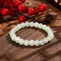Close-up of translucent green and white crystal beads on a textured wooden surface - Light Green and White Style (GBC025-11)
