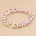 Detail van kralenarmband met lavendel kristallen kralen en gouden infinity bedeltje - Lichtpaars (BC426-5 lt.purple)