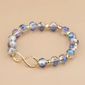 Macro detail van de gefacetteerde kristallen kralen en gouden oneindigheidssymbool op de armband - Blauwpaars (BC426-6)