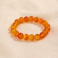 Primer plano de cuentas naranjas translúcidas de 10mm con textura craquelada en tela - Naranja Craquelado (GBC018-3)