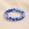 Vue détaillée des perles de 10 mm avec dégradé bleu et blanc sur un fond en tissu texturé - Dégradé Bleu Foncé Blanc (GBC018-19)