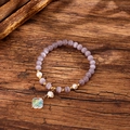 Macro shot of purple cat eye stone beads, freshwater pearls, and clover charm on wood - Purple (GBC09-10)