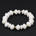 Elastic beaded bracelet featuring matte white geometric wood beads and gold spacers - White