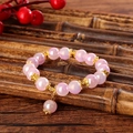 Close-up of pink iridescent crystal beaded bracelet with intricate golden flower spacers - Aurora Pink (GBC07-2)