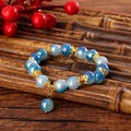 Detail von Perlenarmband mit blauem Aurora-Kristall und goldenen floralen Zwischenstücken - Blau (GBC07-9)