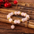 Pink iridescent beaded bracelet with golden floral spacers on a rustic bamboo background - Iridescent Pink (GBC07-3)