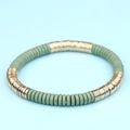 Pulsera bohemia de cuentas planas verde salvia y oro sobre un fondo azul claro suave - Verde Salvia Dorado (BC403-11)