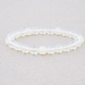 Close-up of 8mm translucent white natural stone beads on a stretch bracelet string - Opal Moonstone Style (BC494-3)