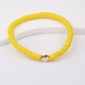 Detail of yellow polymer clay bead bracelet with a gold heart charm on a white stand - Bright Yellow