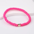 Close-up of pink polymer clay bead bracelet with a gold heart charm on a white stand - Rose Pink