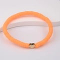 Macro detail of Bohemian bright orange polymer clay bead bracelet with gold heart accent - Bright Orange
