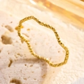 Minimalistischer goldener Wellenring mit schimmernder Textur auf steinigem Hintergrund - Größe 5 / Gold