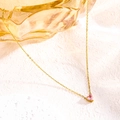 Close-up of golden heart pendant necklace featuring a polished pink zircon heart stone - October Pink