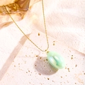 Close-up of a gold titanium necklace with an elegant oval green resin pendant on stone - Light Water Green (81185)