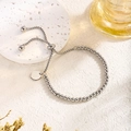 Bracciale regolabile con perline in acciaio argento e ciondolo tondo su sfondo chiaro - Argento
