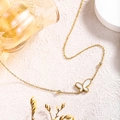 Gros plan détaillé d'un collier pendentif papillon avec incrustation blanche et perles d'or - Collier Papillon (81219) / Or