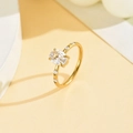 Dettaglio anello in acciaio dorato con zircone ovale centrale e pietre laterali luminose - US 7 / Oro