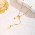 Adjustable gold bunny and carrot pendant necklace with tassel on white marble surface - Gold