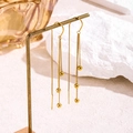 Golden long tassel earrings with multiple chains and beads on a vintage jewelry stand - Rotating Tassel Ear Wire / Gold