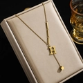 Halskette aus Titanstahl in Gold mit Buchstabe H Anhänger und asymmetrischem Vierkantstab - Buchstabe H