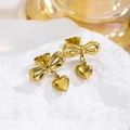 Boucles d'oreilles nœud et cœur dorées sur pierre blanche avec lumière élégante - Boucles d'Oreilles Clous Noeud